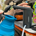 Camping water pump being used to fill a blue collapsible cup with a vehicle in the background.